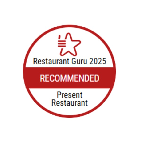 Restaurant Guru 2025 Recommended badge for Present Restaurant, a red and white circular logo.