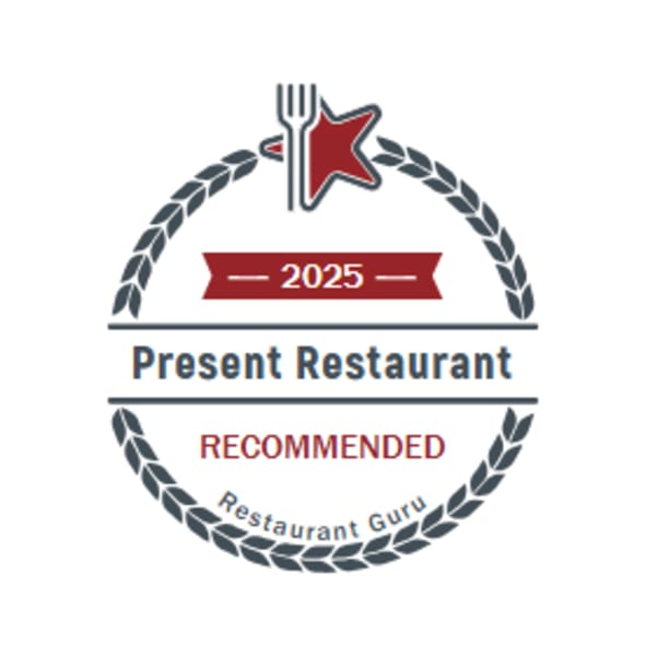 Present Restaurant's 2025 Restaurant Guru Recommended badge, featuring a fork and star.