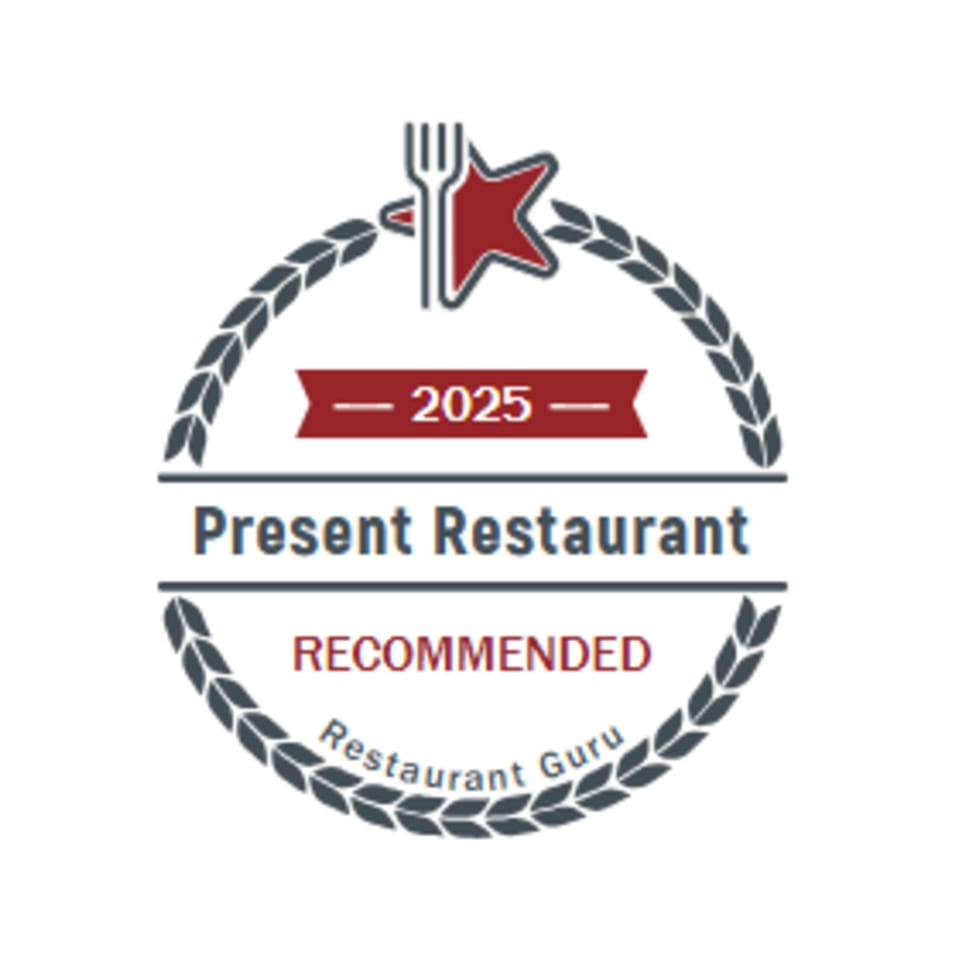 Present Restaurant's 2025 Restaurant Guru Recommended badge, featuring a fork and star.